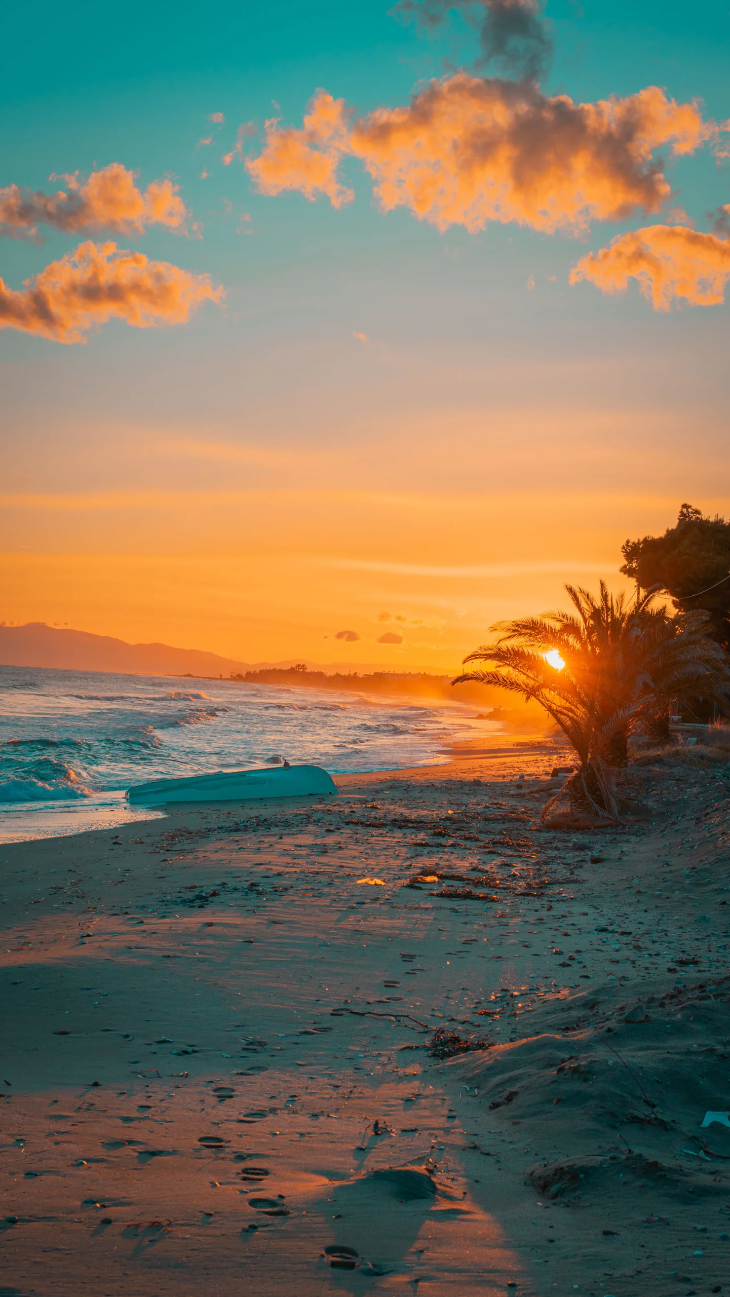 Beach at sunset with waves and orange clouds