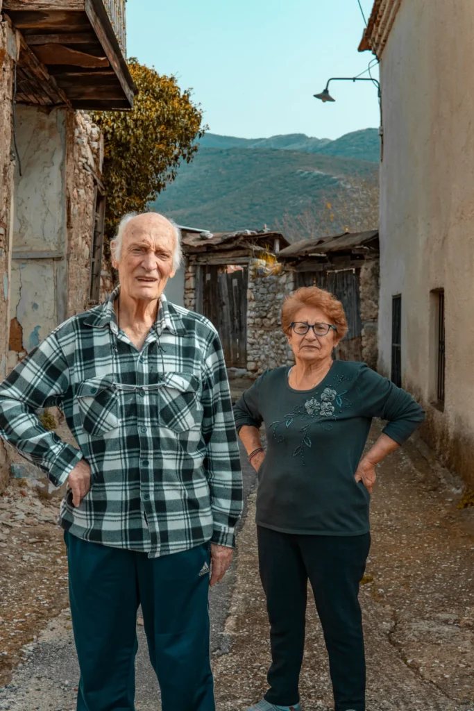 Elderly couple standing in a narrow village street