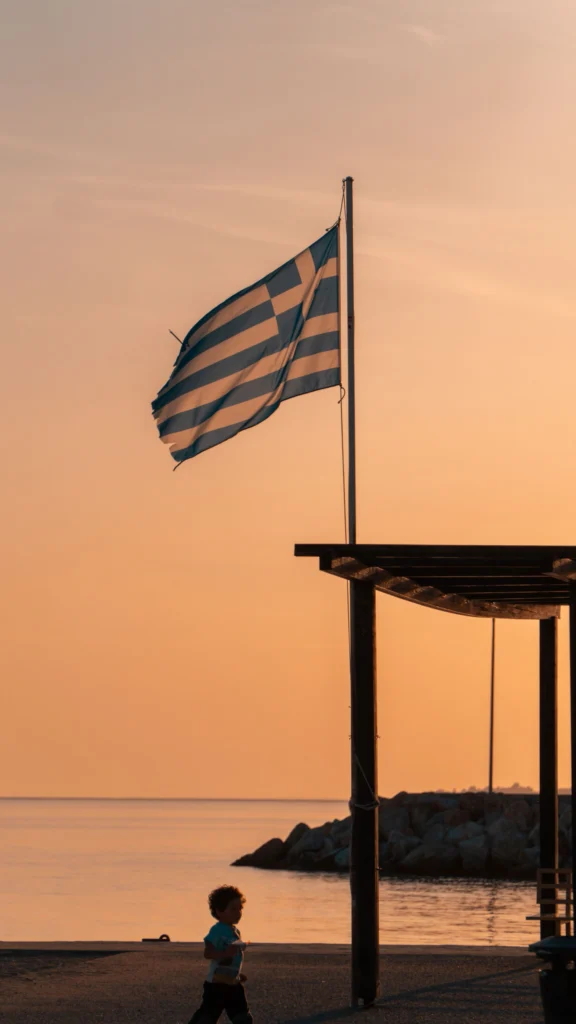Greek flag above the sea at golden hour